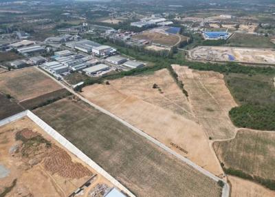 Aerial view of an expansive undeveloped land near industrial area
