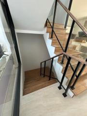 Modern staircase with wooden steps and metal railings in a house interior