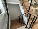 Modern staircase with wooden steps and metal railings in a house interior