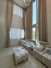 Spacious living room with high ceiling and natural light