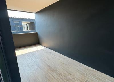 Modern balcony with wooden flooring and dark wall paint