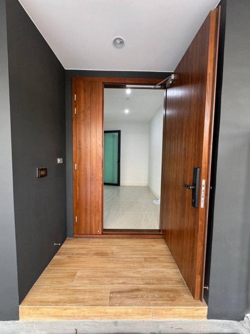 Modern entrance hallway with wooden door and tiled flooring