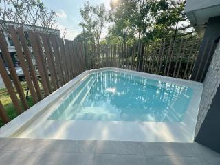 Private swimming pool with wooden fence and adjacent patio