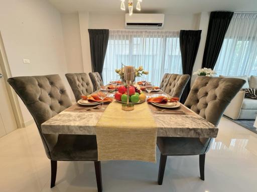 Elegant dining room with table set for six, modern furniture, and neutral color palette