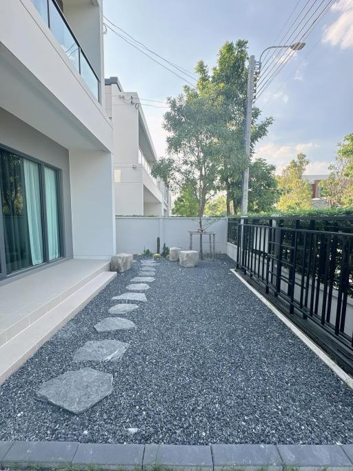 Modern home exterior with stone pathway and lush greenery