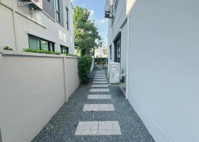 Pathway leading between modern residential buildings with greenery