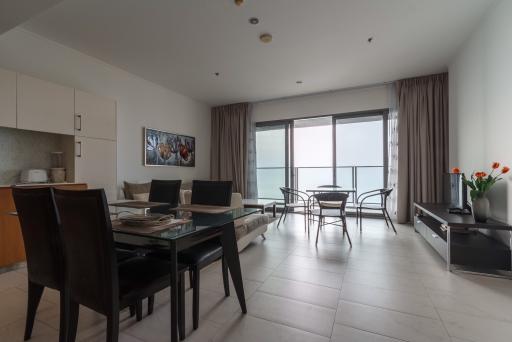 Spacious living room with ocean view, dining area, and balcony access