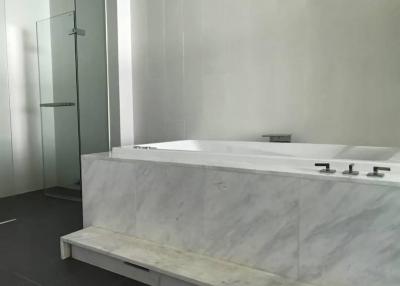 Modern bathroom with marble bathtub and glass shower