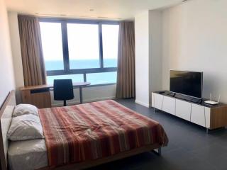 Spacious bedroom with a sea view, large bed, and modern furnishings