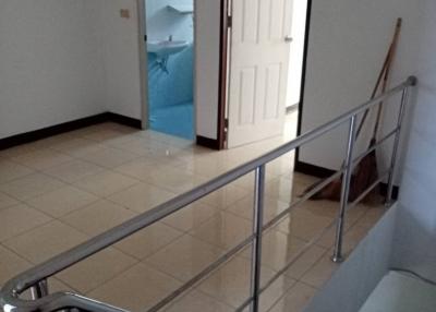 Stainless steel railing along a tiled staircase with doors leading to different rooms