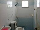 Compact bathroom with tiled walls and light blue flooring