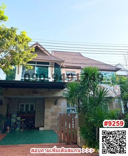 Front view of a two-story house with a carport and greenery