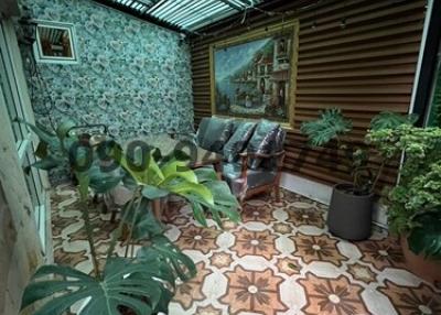 Enclosed patio space with patterned tile flooring and an array of plants