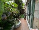 Cozy outdoor patio with greenery and wooden flooring by the house