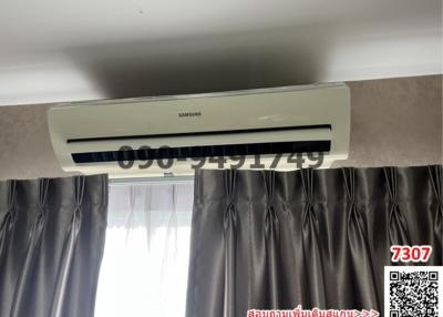 Air conditioner above curtains in a nondescript room