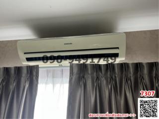 Air conditioner above curtains in a nondescript room