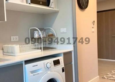 Compact laundry room with modern appliances and storage shelves