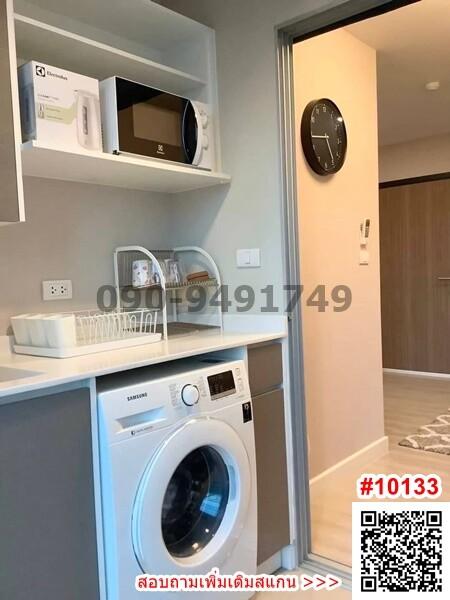 Compact laundry room with modern appliances and storage shelves