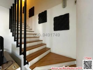 Modern staircase with wooden steps and black accents in a well-lit space