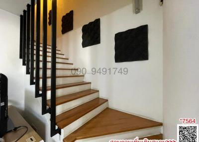 Modern staircase with wooden steps and black accents in a well-lit space
