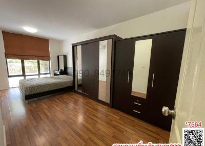 Spacious bedroom with large bed and wooden floor