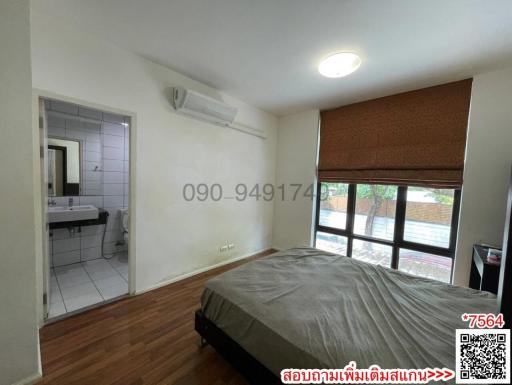 Spacious bedroom with attached bathroom and large window