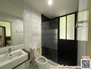 Modern bathroom interior with white tiles and glass shower partition