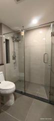 Modern bathroom with glass shower enclosure and tiled walls