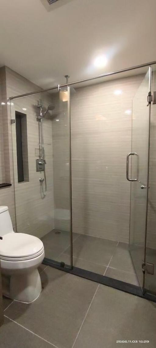 Modern bathroom with glass shower enclosure and tiled walls