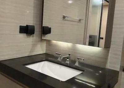 Modern bathroom with sleek finishes and well-lit mirror