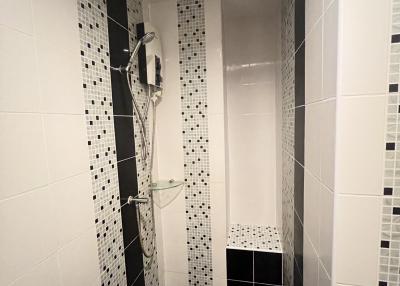 Narrow tiled bathroom with walk-in shower