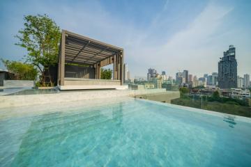 Luxurious rooftop swimming pool with city skyline view and lounge area