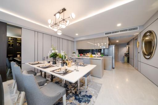 Modern dining area adjacent to an open-plan kitchen with elegant furnishings