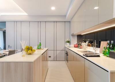 Modern kitchen with neutral tones, integrated appliances, and ample lighting