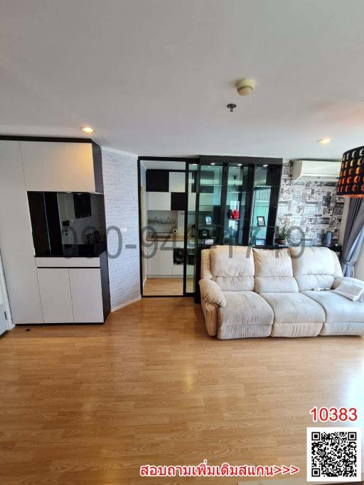 Modern living room with a comfortable sofa, hardwood floors, and plenty of natural light