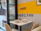 Modern dining area with two chairs and a small table against a vibrant yellow accent wall