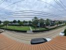 Spacious balcony with a panoramic suburban view featuring a hammock and basketball hoop