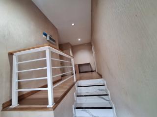 Modern staircase with wooden steps and white railing inside a home