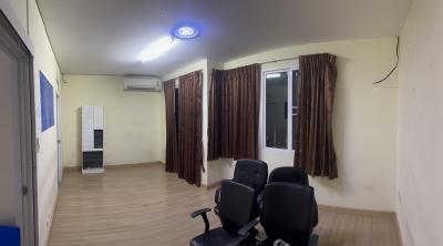 Spacious room with chairs, air conditioning unit, and large windows with curtains