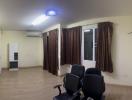 Spacious room with chairs, air conditioning unit, and large windows with curtains