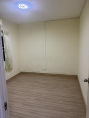 Empty bedroom with wooden flooring and pale yellow walls