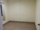 Empty bedroom with wooden flooring and pale yellow walls