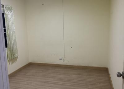 Empty bedroom with wooden flooring and pale yellow walls