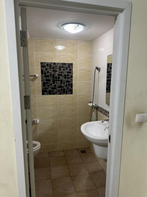 Compact bathroom with tiled walls and modern fixtures