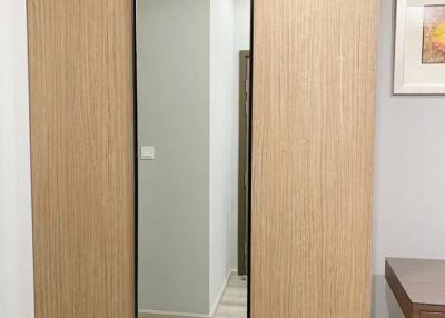 Modern bedroom closet with sliding doors reflecting a hallway