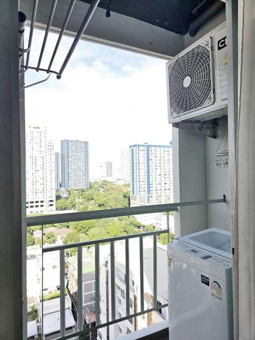 High-rise apartment balcony with outdoor air conditioning unit and washing machine overlooking cityscape