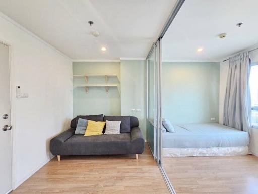 Compact bedroom with a sofa and mirrored wardrobe