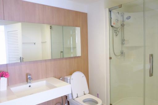 Modern bathroom with glass shower and wooden cabinets