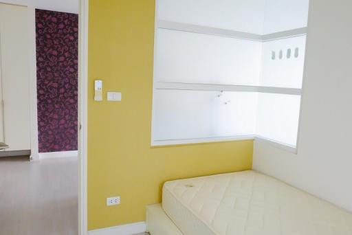 Bright bedroom with a single bed and yellow walls