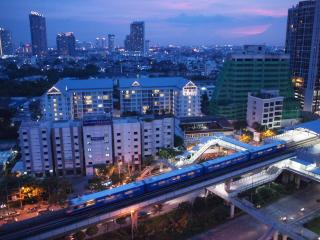 Aerial view of a cityscape at dusk with buildings and a moving train